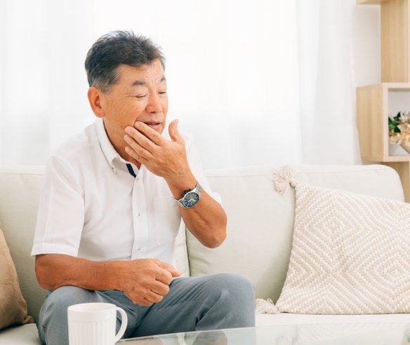 入れ歯の不調で口元を気にする男性
